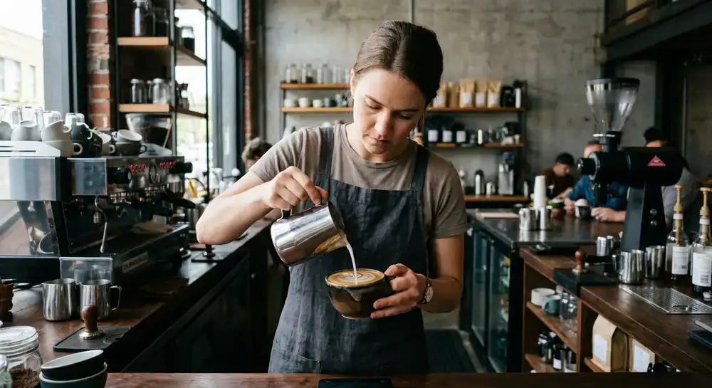 Barista carefully pouring latte art